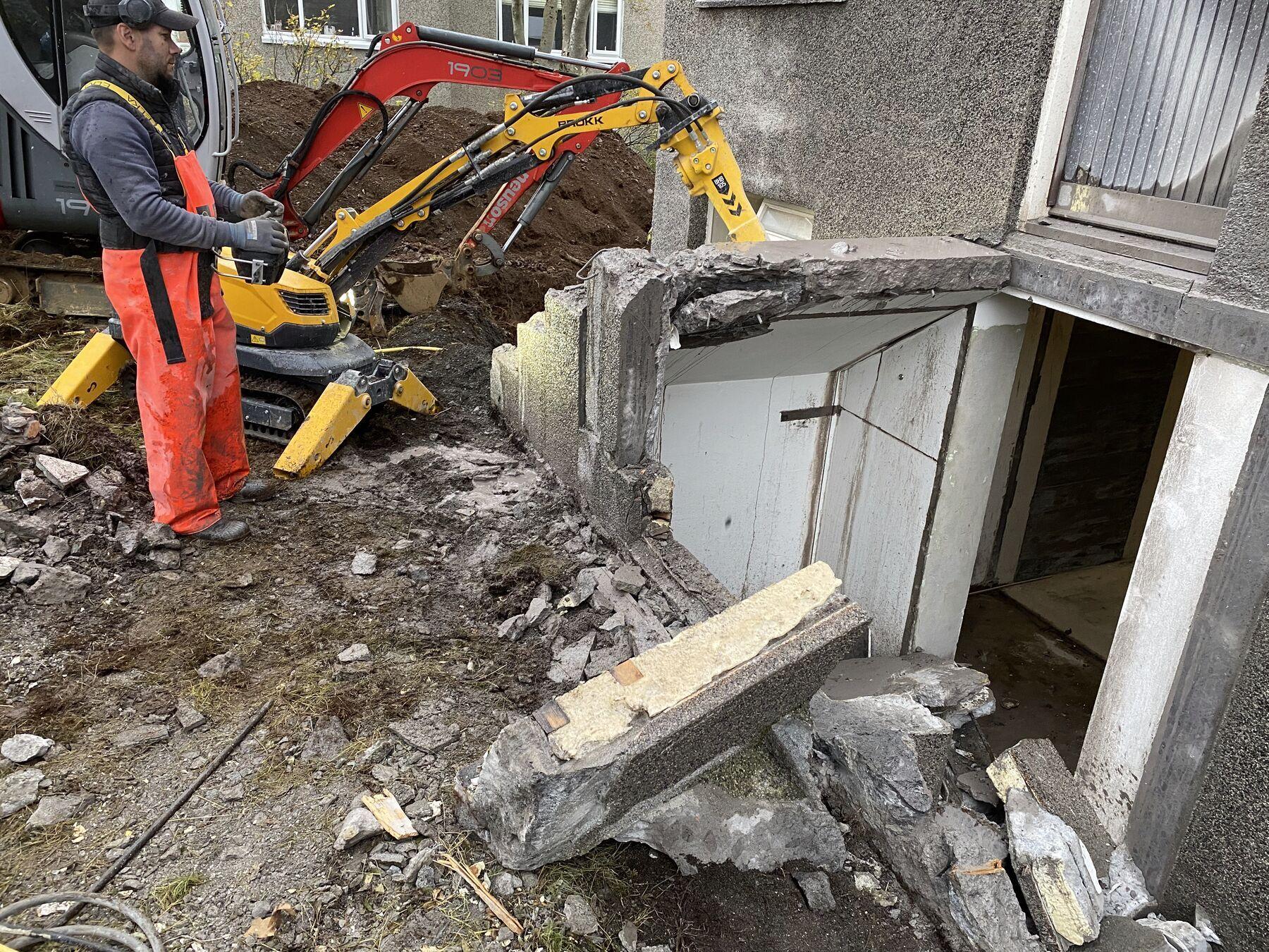 Fjarstýrð brotvél brýtur kjallaravegg við íbúðarhús